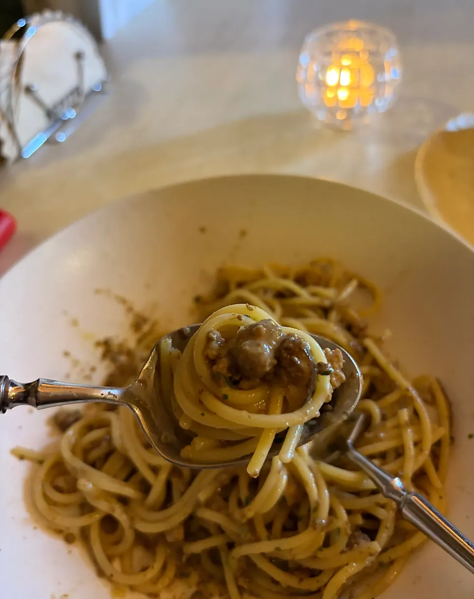 A scooped-out bite of white ragu pasta