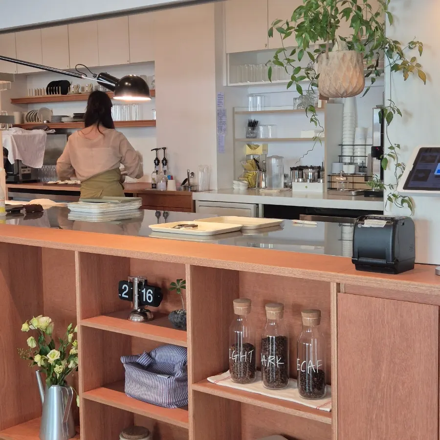 Café interior featuring plant-interior touches with lighting and potted plants