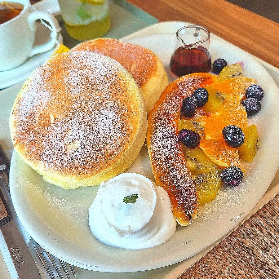 Eating the fruit soufflé topped with whipped cream and fruit