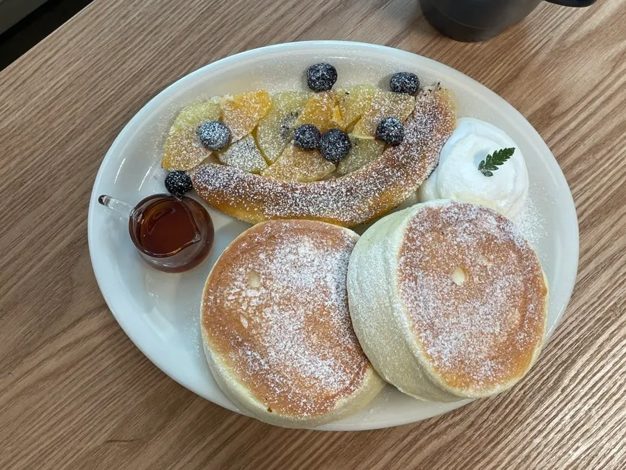 Pouring maple syrup over the soufflé pancake