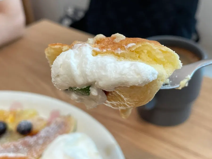 A forkful of soufflé with whipped cream