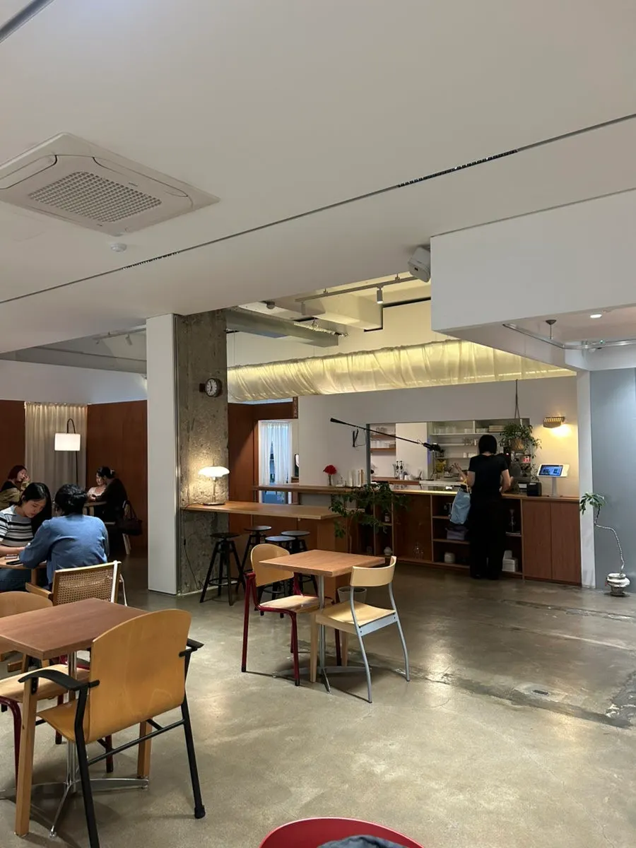 Petrico's interior with high ceilings, wood-tone furniture and beige walls