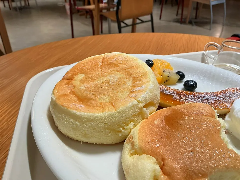 A piece of soufflé cut with a knife, topped with cream and fruit