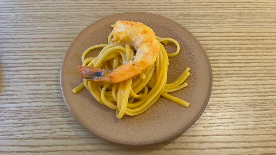 Plate of bisque pasta topped with plump shrimp