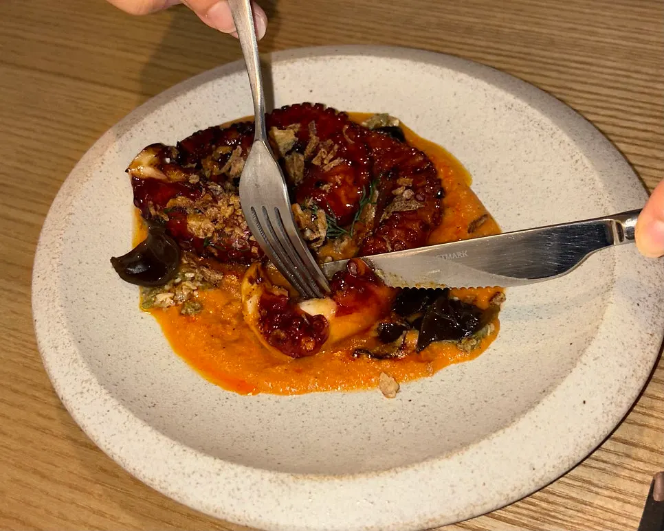 Charcoal octopus served with paprika-based romesco sauce