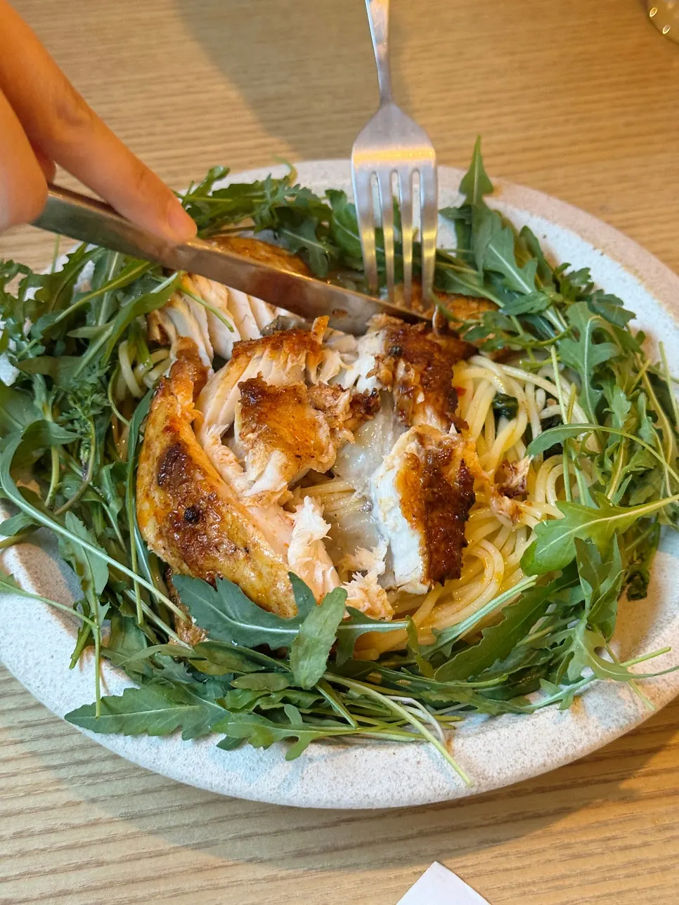 Close-up of the pasta topped with arugula and mackerel