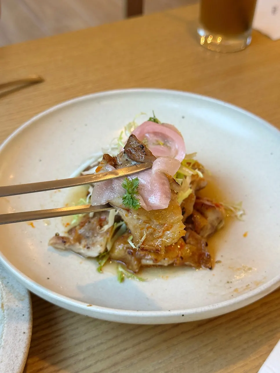 Chicken thigh topped with pickled onion and pickled gungchae