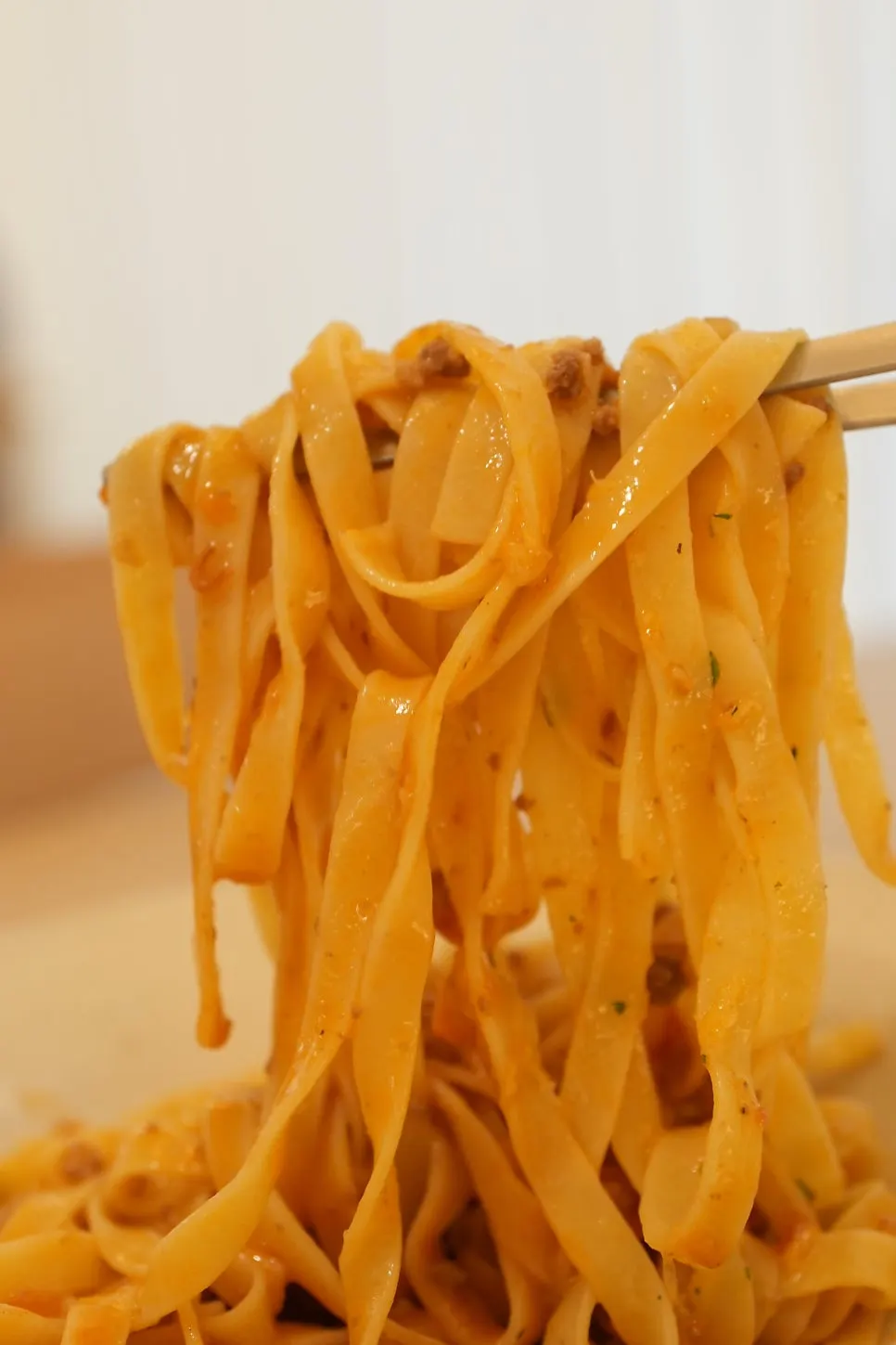 Close-up of pasta strands coated in rich ragu sauce