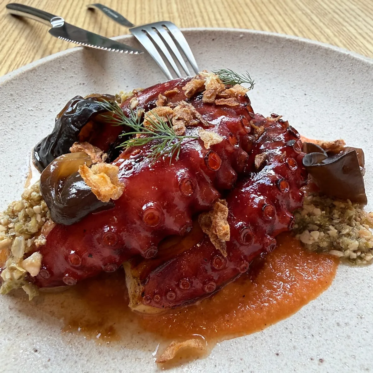 A serving of charcoal octopus and romesco at Pyu Euljiro