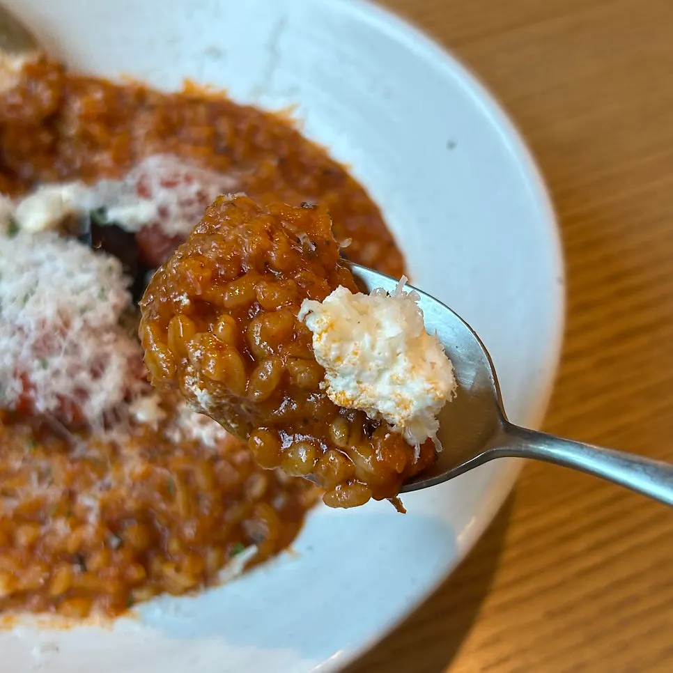Garden tomato risotto topped with ricotta cheese and roasted tomato