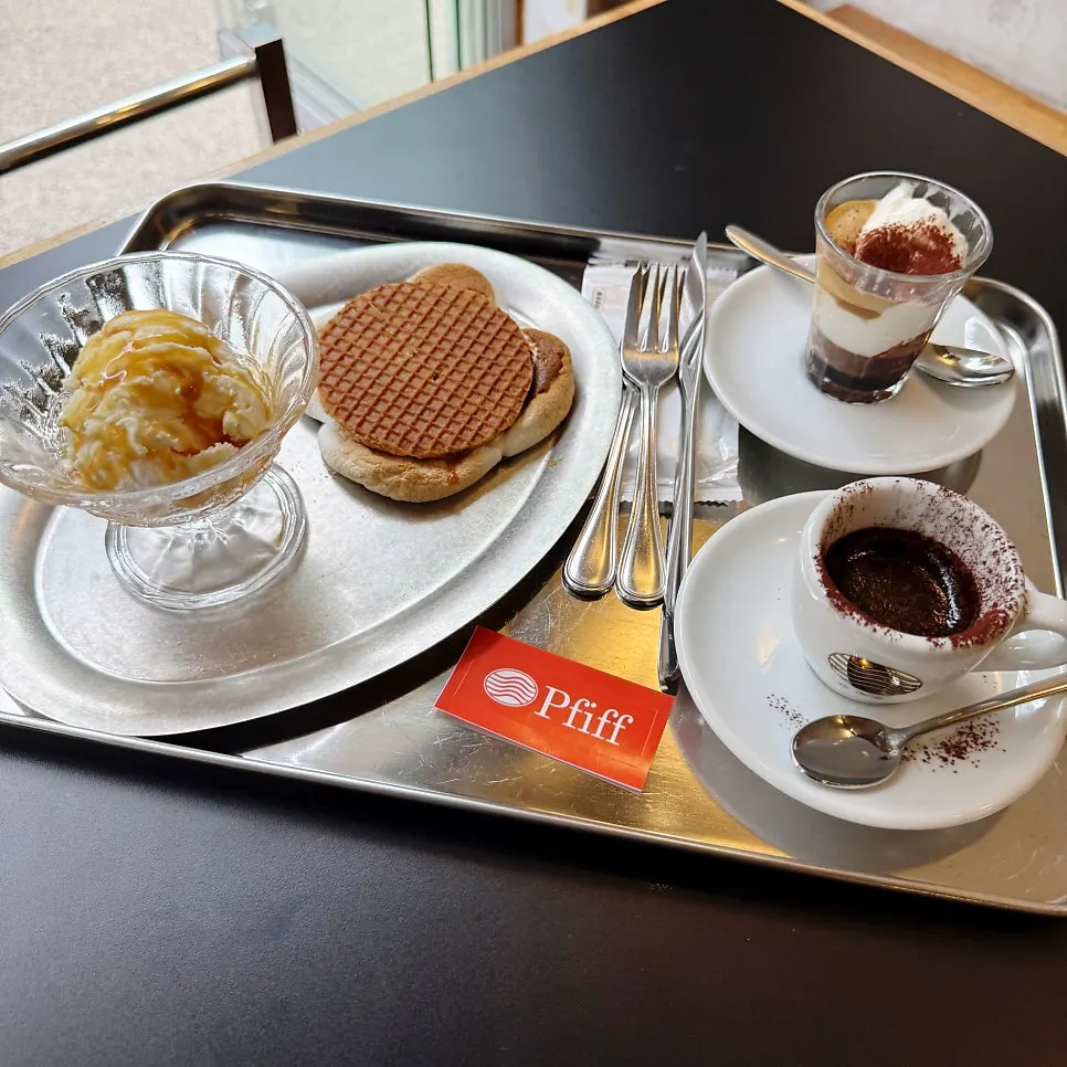 Coffee and dessert served on a stainless steel tray