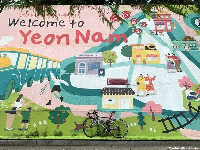 Bicycle parked in front of a large mural at the northern edge of Yeonnam-dong