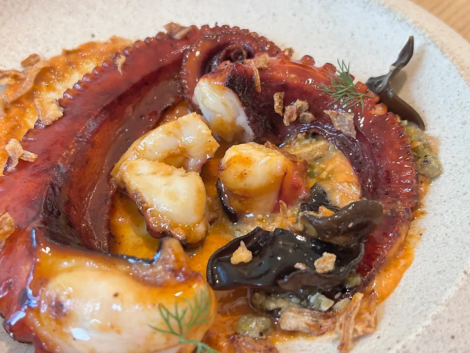 Charcoal octopus plate served alongside pasta