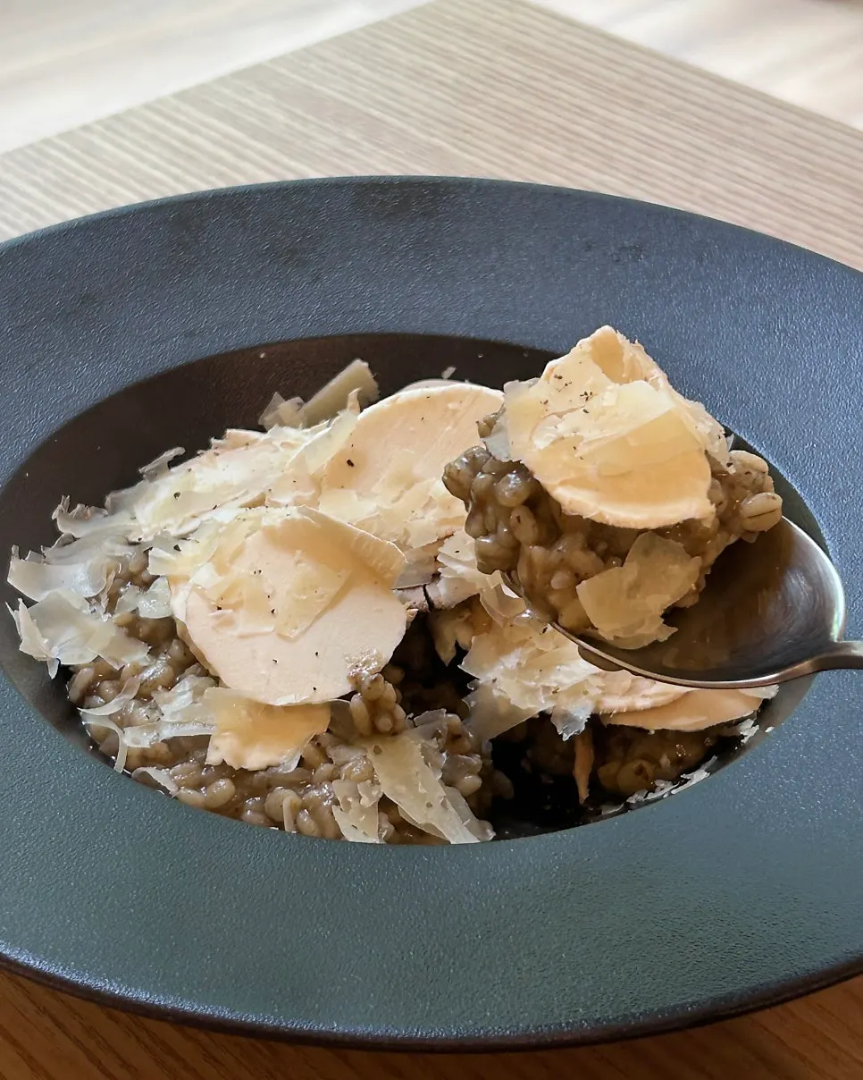 A spoonful of truffle risotto topped with mushrooms