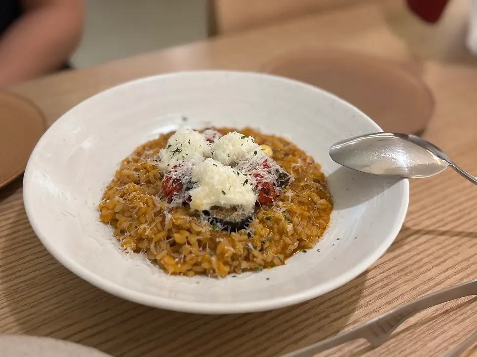 Tomato risotto topped with roasted vegetables