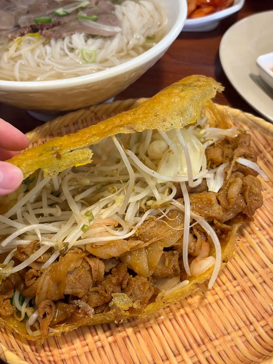 Cross-section of banh xeo filled with shrimp and bean sprouts