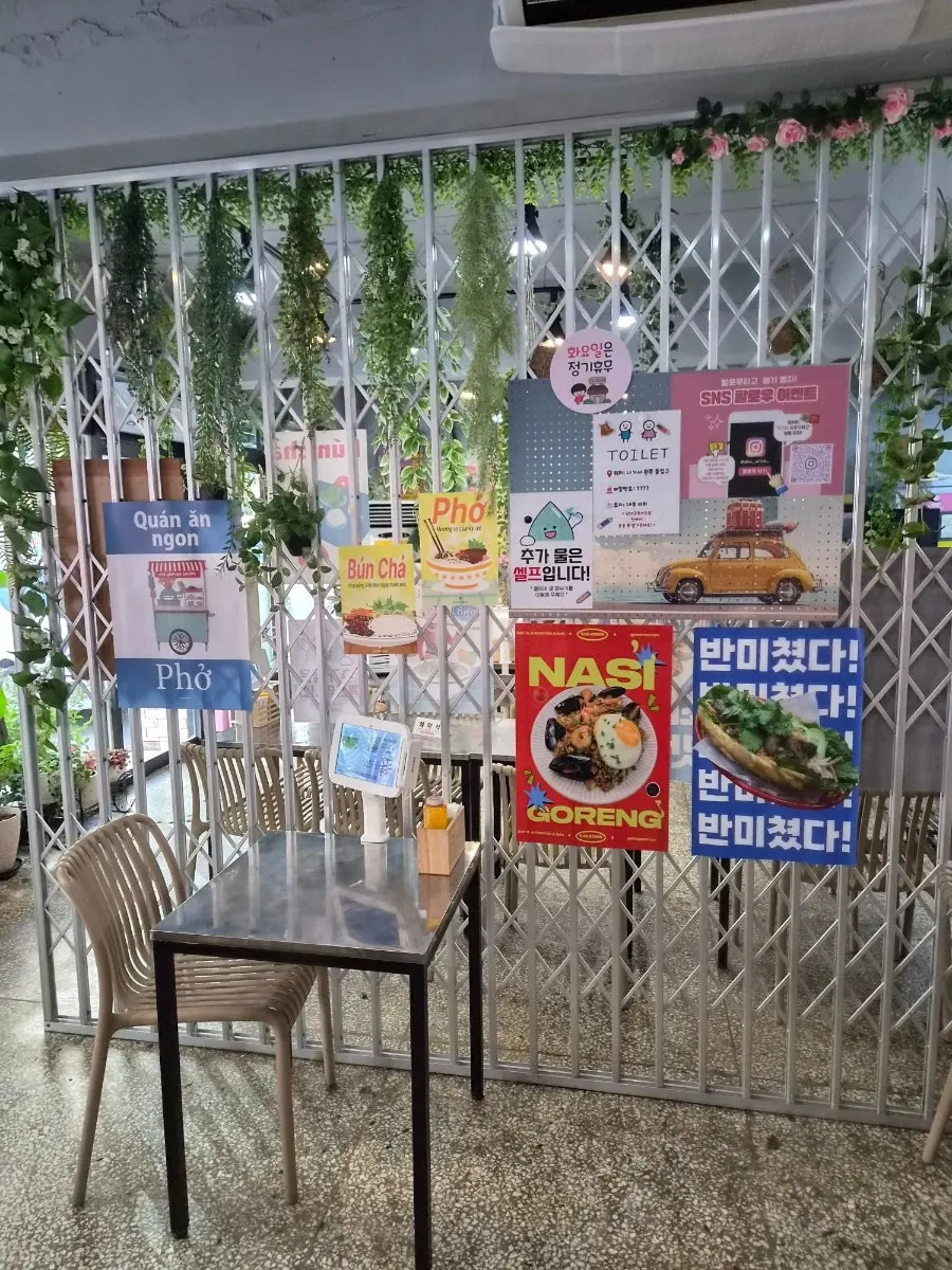 Interior of Pho Witch decorated with green plants and pink walls