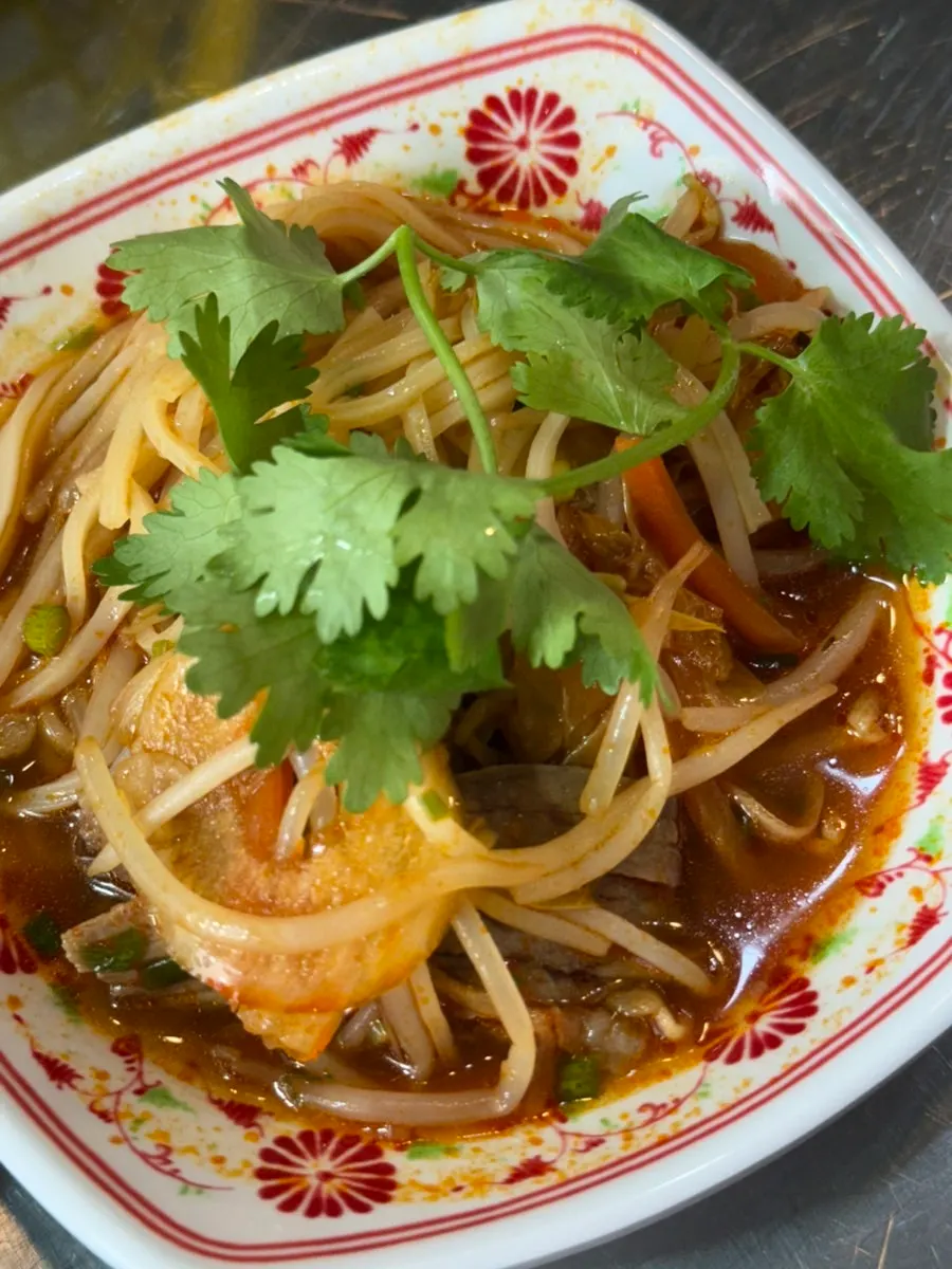 A bite of pho topped with cilantro
