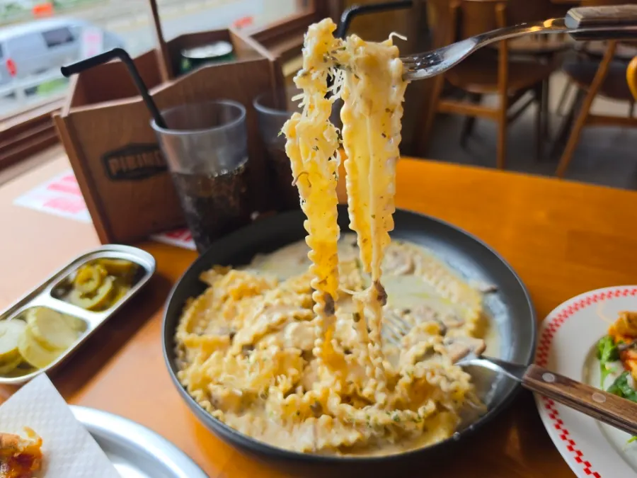 Cream pasta noodles wound around a fork