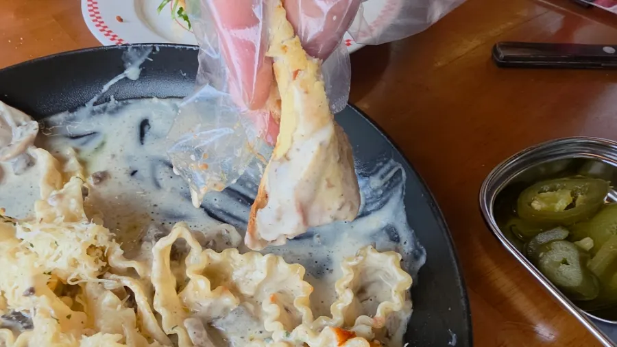 Dipping a pizza crust into the cream sauce