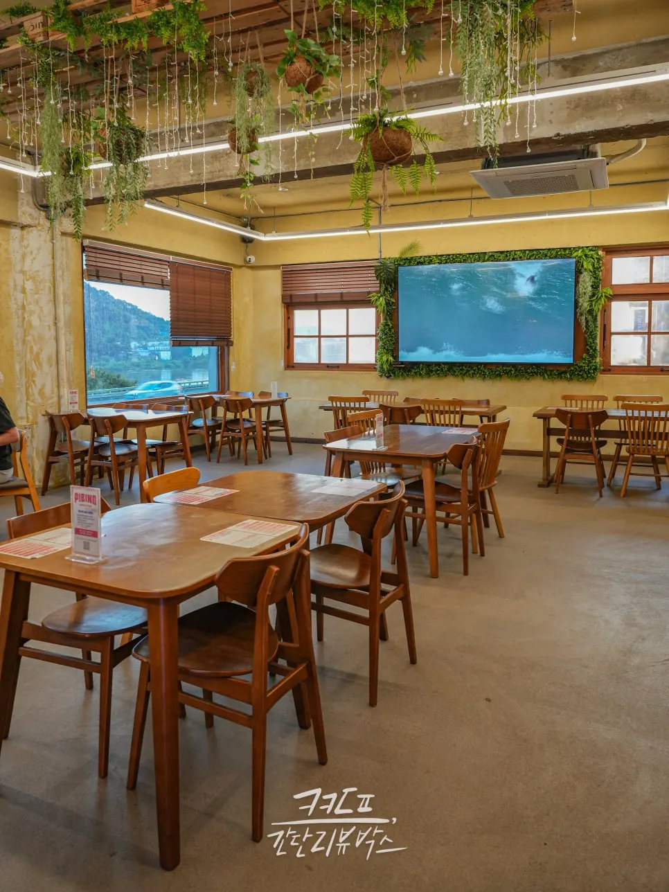 2nd floor tables with a TV screen in the background