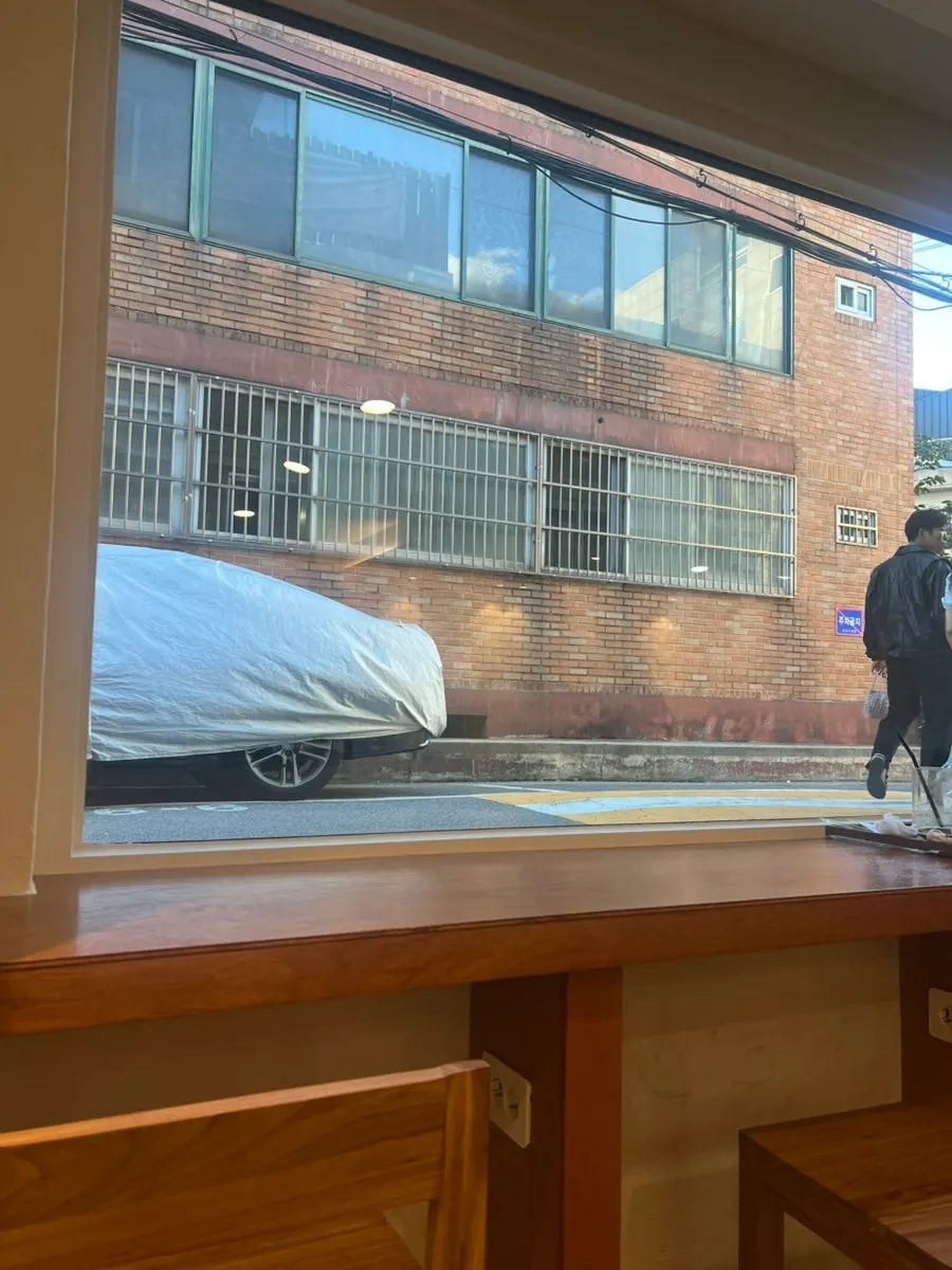 통창 밖 골목 풍경이 보이는 창가 자리