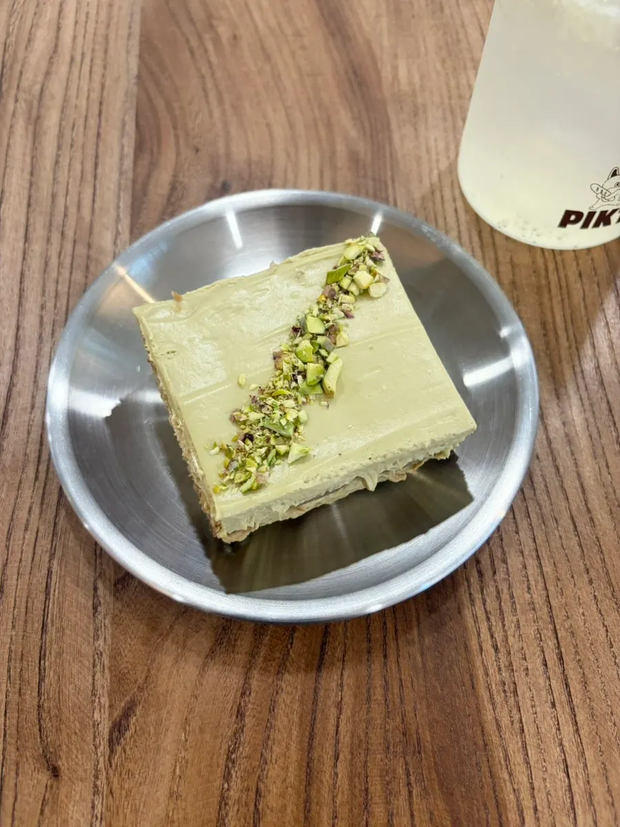 커피와 함께 놓인 피스타치오 티라미수