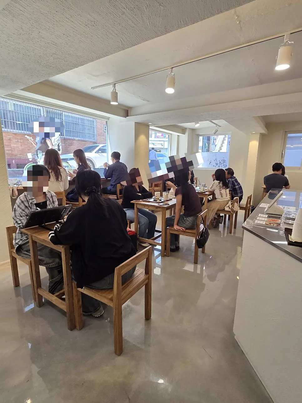 Café interior seating with sunlight streaming through a picture window