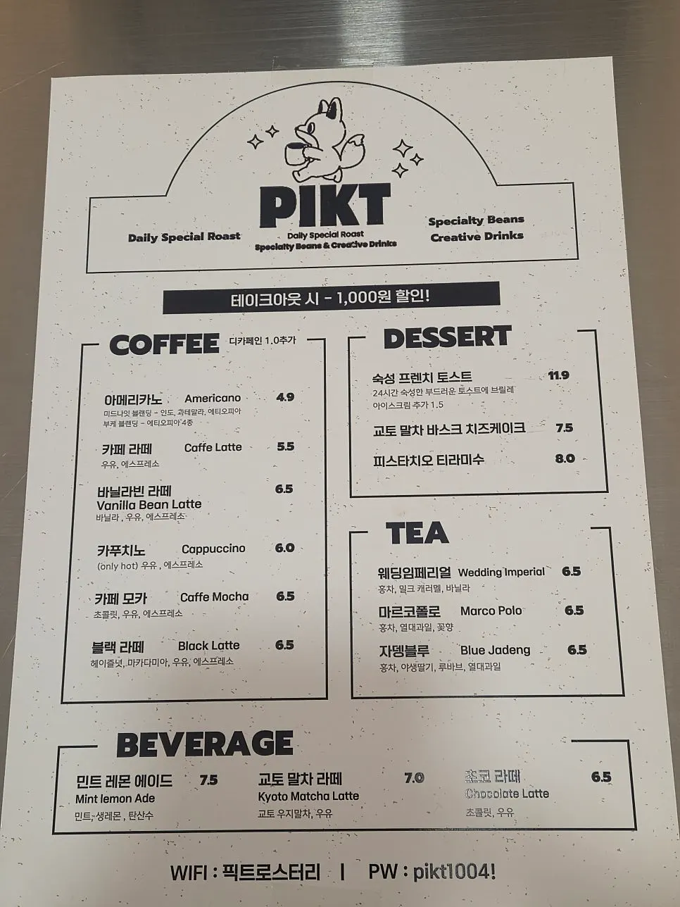 Café menu board listing black tea, matcha latte, and more