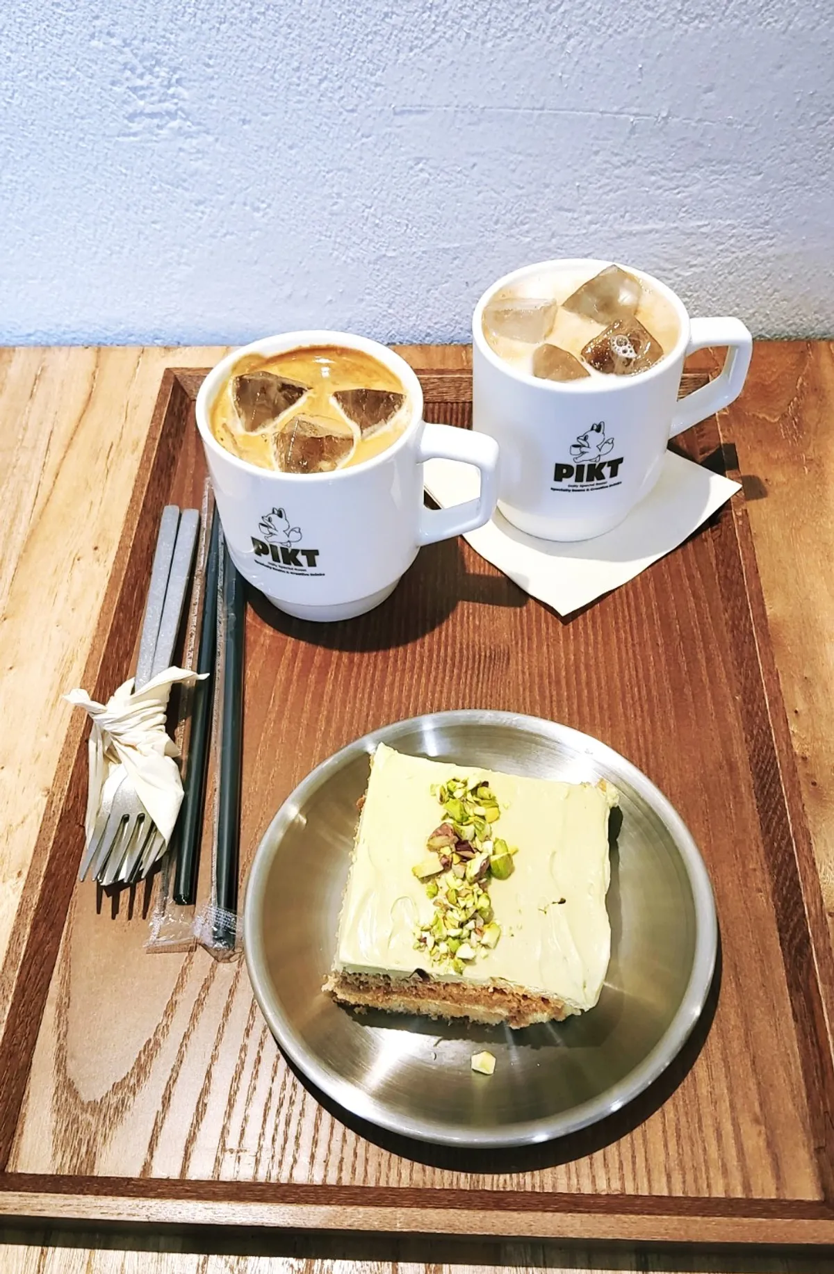 Overhead shot of pistachio tiramisu and two iced coffees