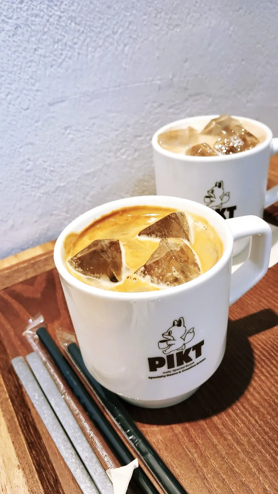 Cup with PICT Roastery logo next to dessert