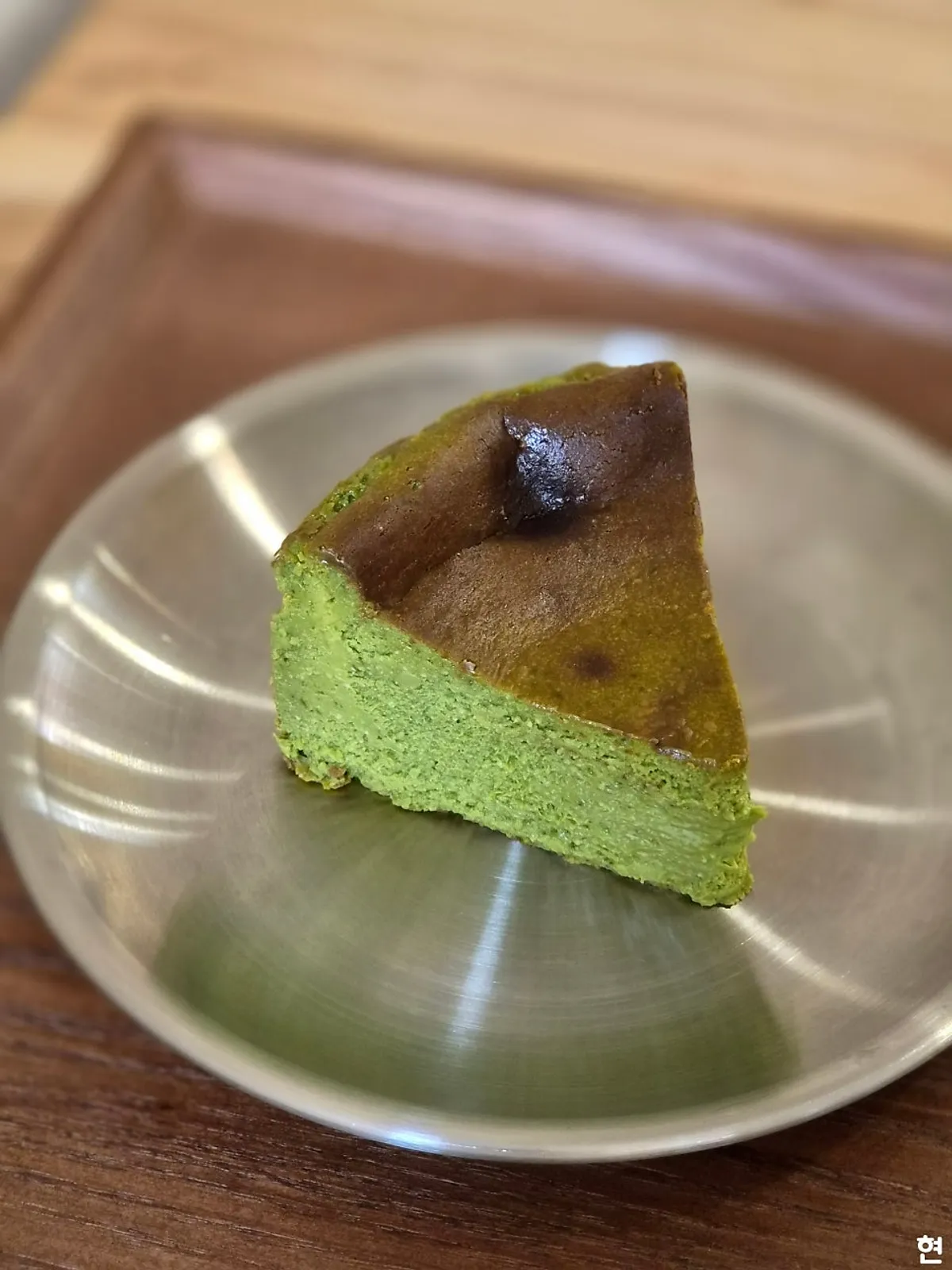 A slice of deep-green matcha Basque cheesecake
