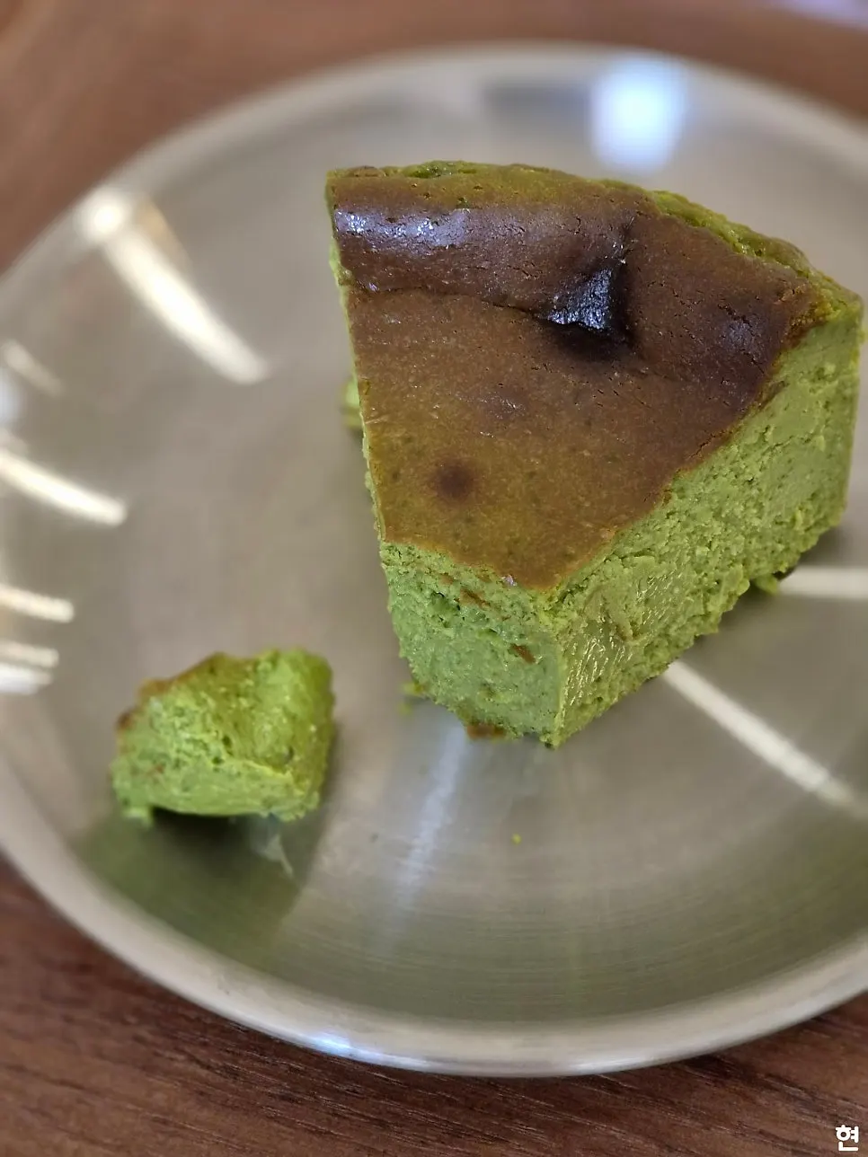 A forkful of matcha Basque cheesecake showing its inside texture