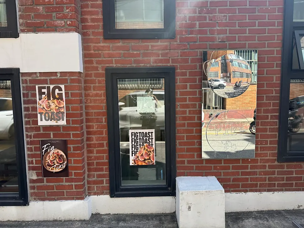 Round mirror and FIG TOAST poster on the exterior wall