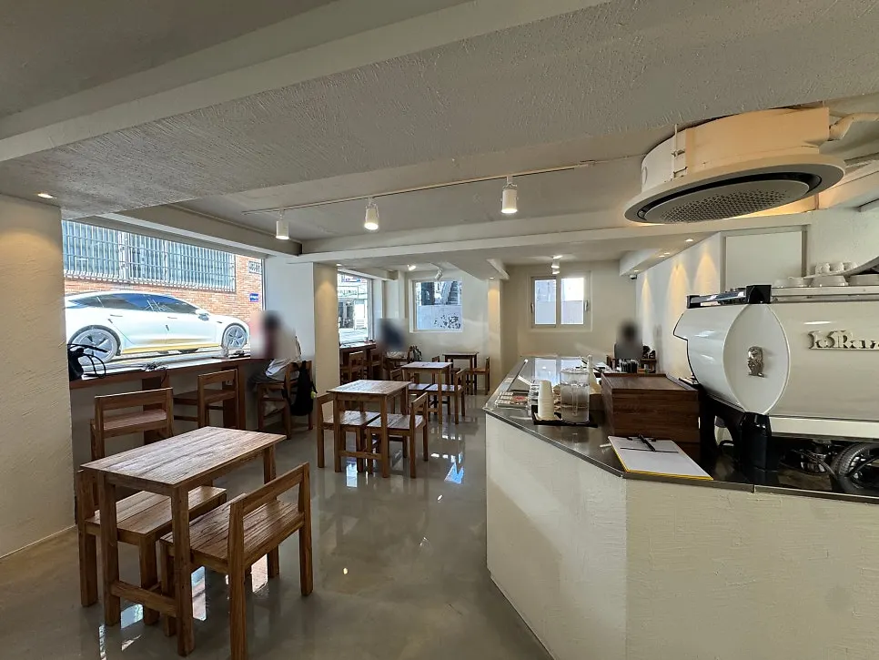 Café interior with white-toned walls and wooden tables