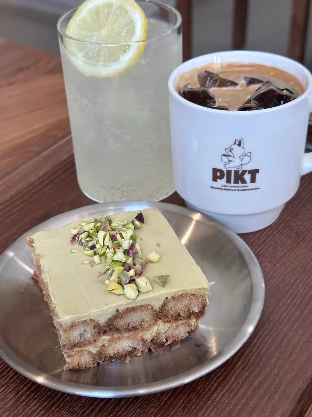 Americano, lemonade, and pistachio tiramisu laid out together