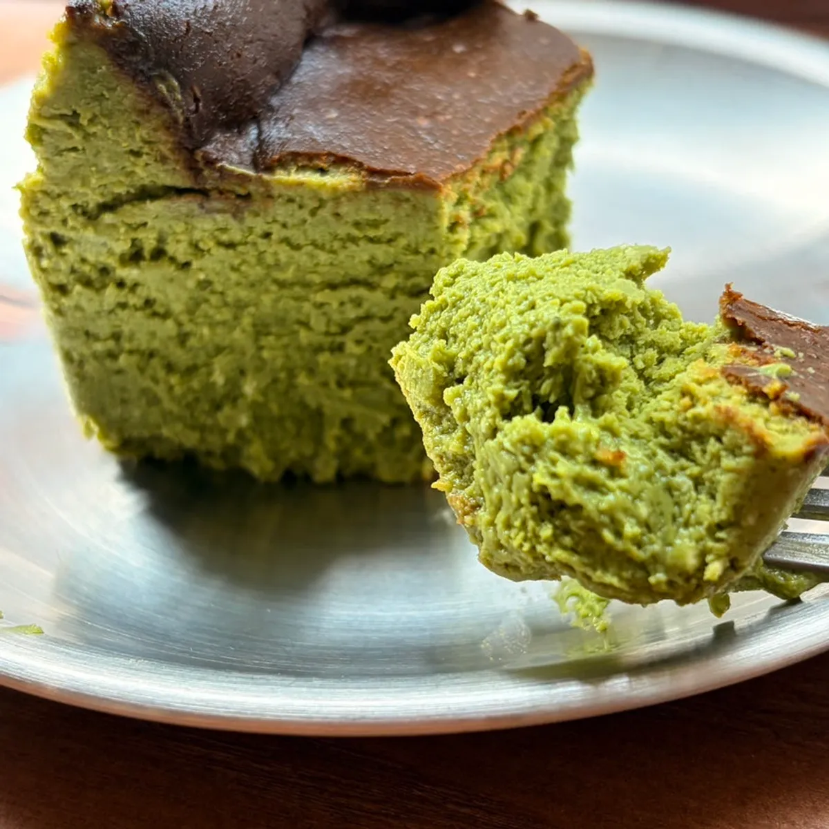 Matcha Basque cheesecake and coffee at a window table
