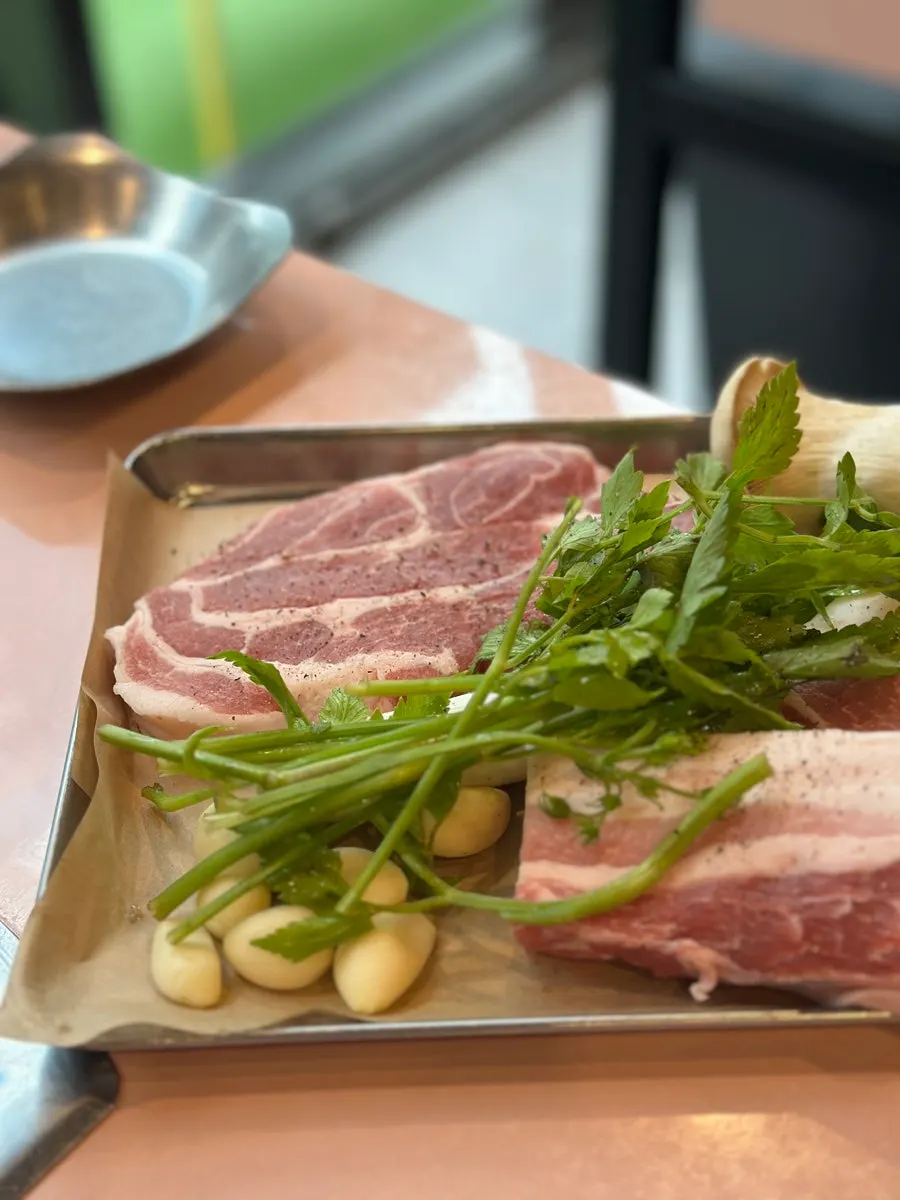 Pork belly and pork neck placed on the grill at Dwaeji Mansion