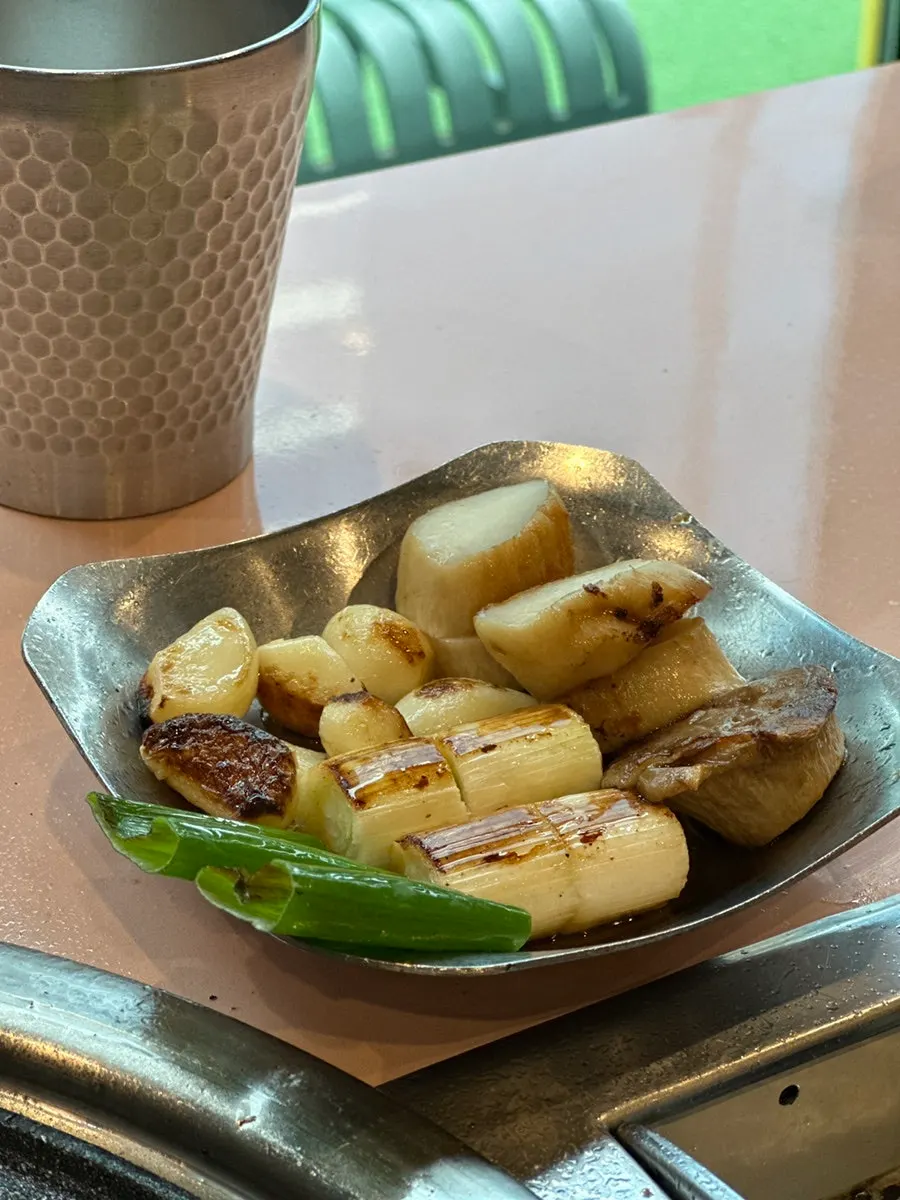 Meat cut into bite-sized pieces alongside grilled vegetables