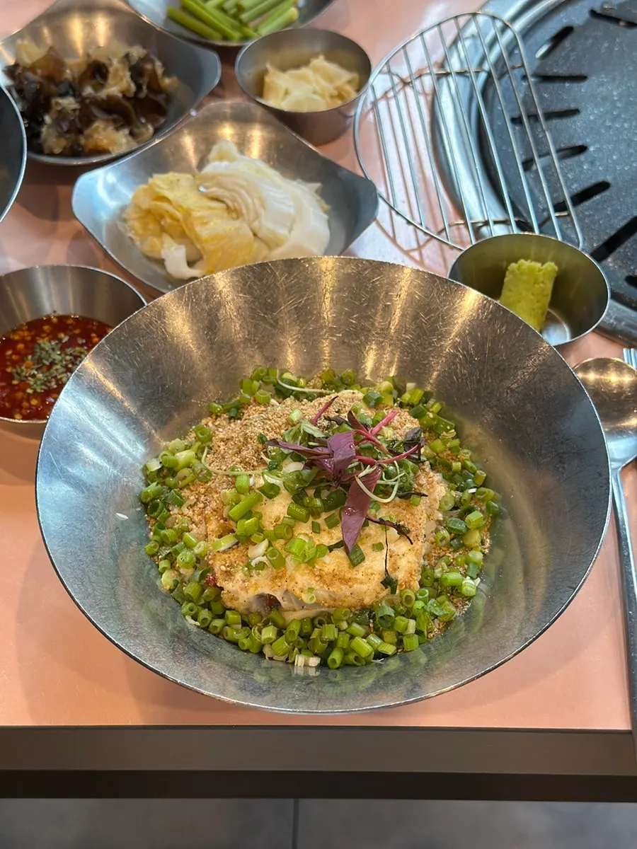 A piece of pork belly topped with herring roe on water dropwort