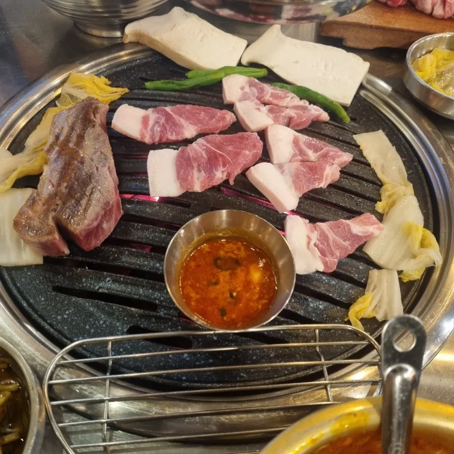 구워진 고기와 곁들임 반찬이 놓인 테이블