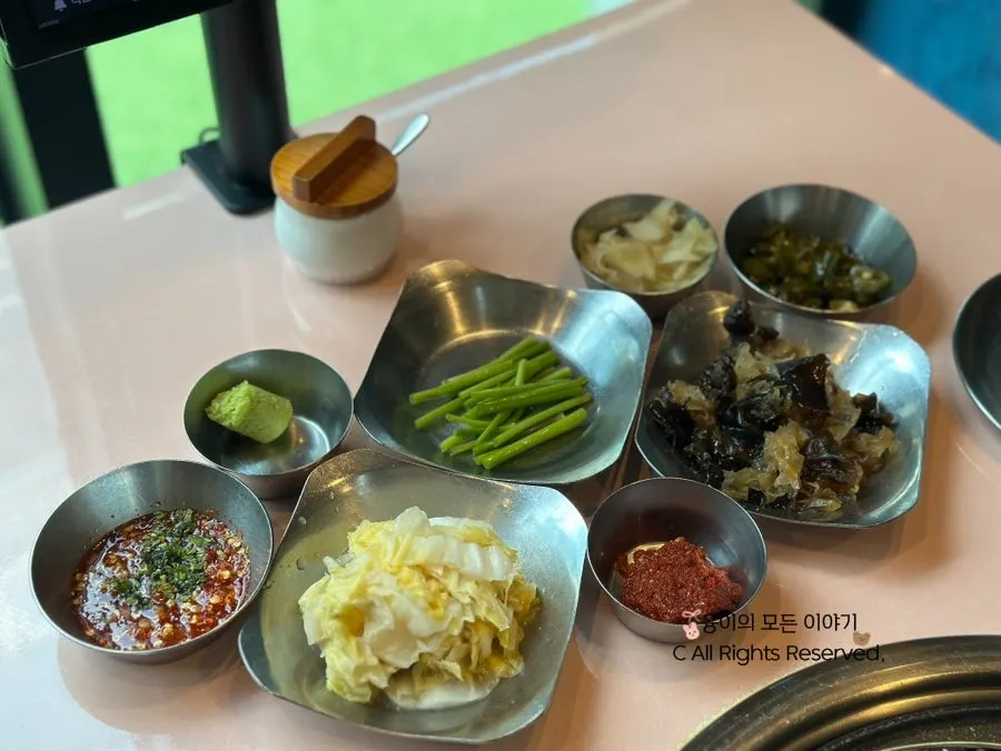 Side dishes and sauces including herring roe, garlic scapes, and white kimchi