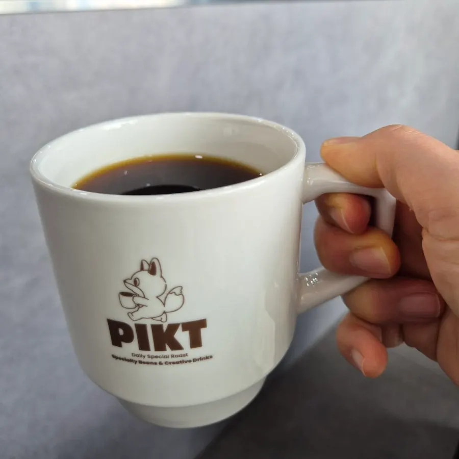 Holding the hand-drip cup up to smell the aroma