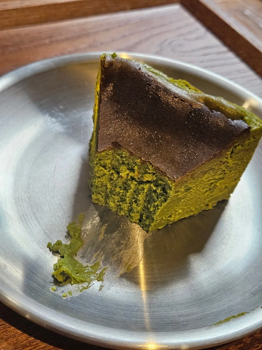 Cross-section of matcha Basque cheesecake cut with a fork