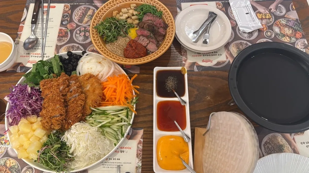A full table with Filling wrapped katsu and flat iron steak bibimbap
