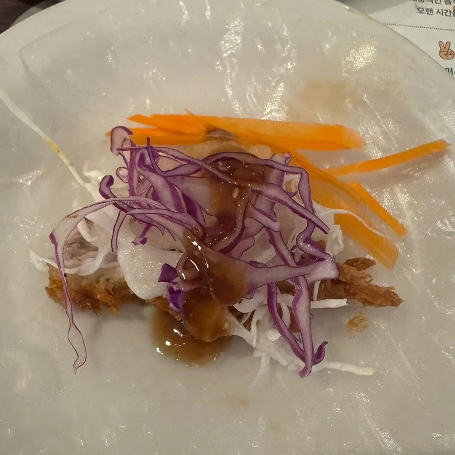 A wrapped bite of katsu dipped in sauce