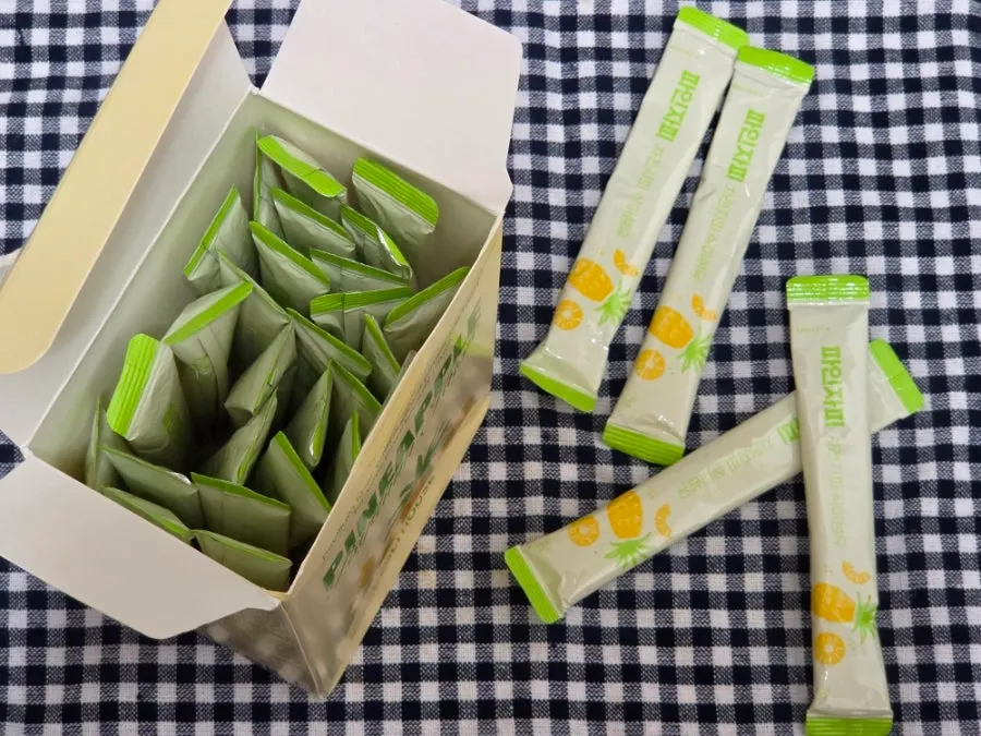 Pinejapi stick packaging next to a cup of water