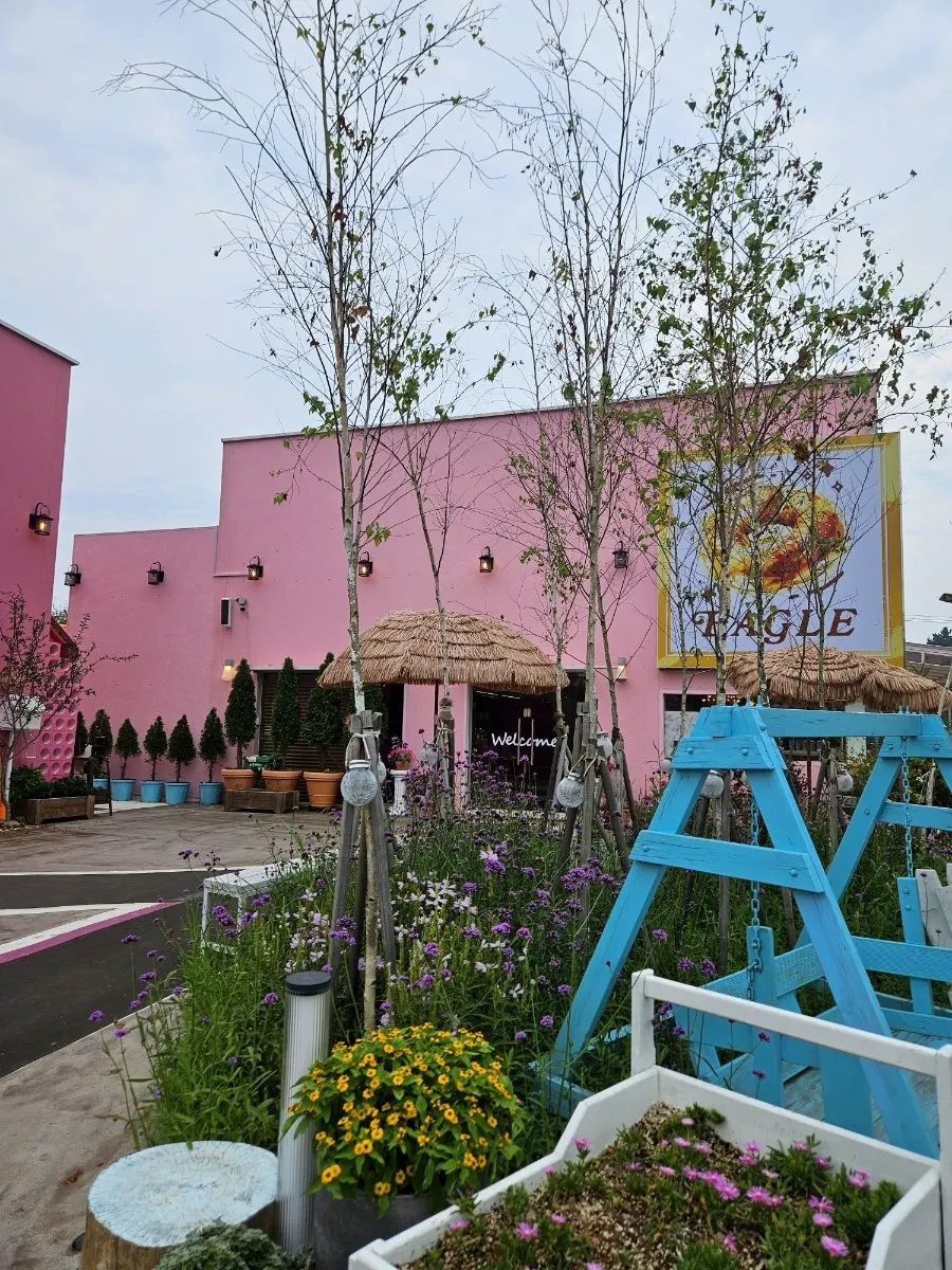 Pink exterior and terrace plants at Pink Wall Cafe in Yeongjong