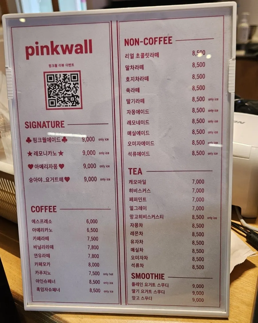 Floor-to-ceiling windows and blossom decor at Pink Wall Cafe