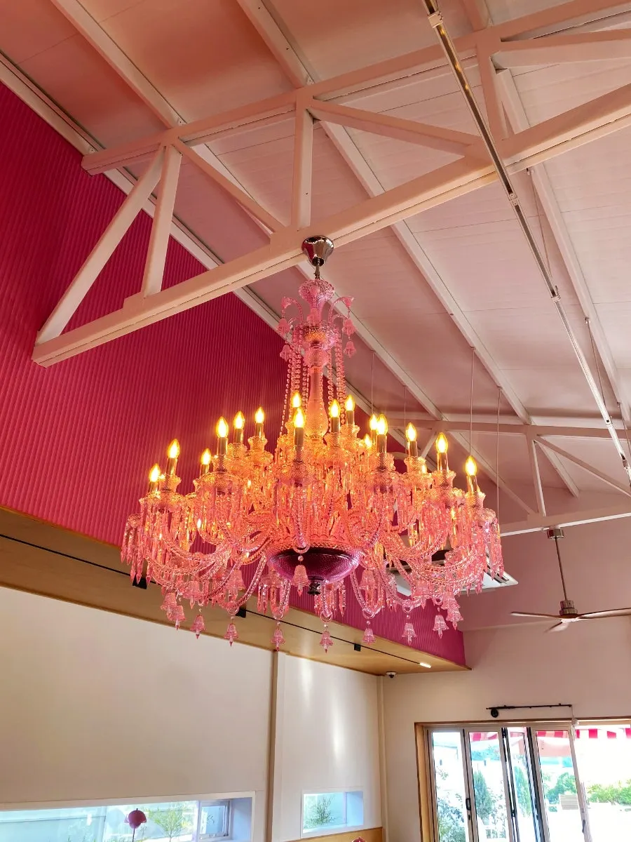 Large pink chandelier hanging from the ceiling at Pink Wall Cafe